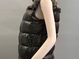 the mannequin is wearing a black vest with a chain around the neck