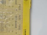 a yellow ticket on a white table next to a white wall