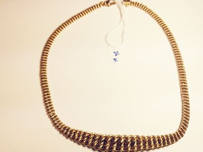 gold plated chain necklace with a tassel on a white background
