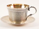 an antique silver cup and saucer on a saucer on a white background