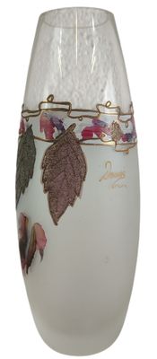 a glass vase with a design of leaves on it