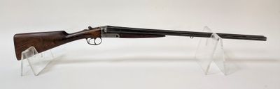 un fusil au canon en bois posé sur un socle en acrylique transparent