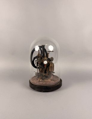 figurine of a steam engine under a glass dome on a wooden base
