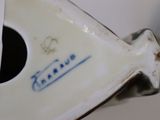 a close up of a white vase with a tag on it
