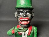 une statue verte et rouge représentant un homme portant un chapeau et une cravate