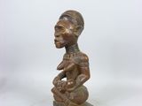 a wooden statue of a woman with a bird on her shoulder