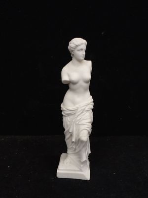 a white statue of a woman on a black background