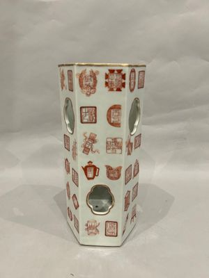 a white vase with red and white designs on it