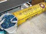 a large roll of blue and yellow scissors next to a pile of other blue and yellow scissors