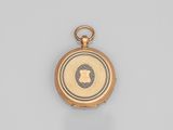 a close up of a gold pocket watch on a white surface