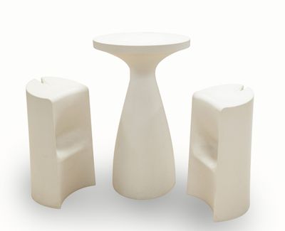 une table blanche et deux tabourets placés l'un à côté de l'autre