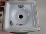 a person holding a small white bowl with a hole in it
