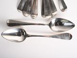 five spoons and two spoons on a white table