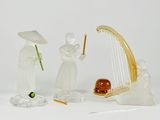 three figurines of people with musical instruments on a white surface