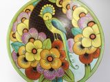 a colorful plate with a bird and flowers on it