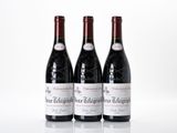 trois bouteilles de vin rouge posées l'une à côté de l'autre sur une surface blanche