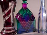 three different colored glass vases sitting next to each other