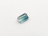 a blue green tourmaline gems on a white surface