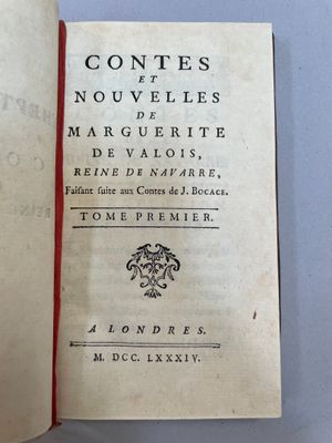 un livre ouvert sur une table blanche avec un ruban rouge