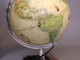 a small globe on a wooden stand with a cable