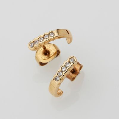 a pair of gold and diamond ear cuffs