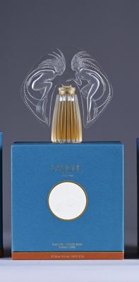two bottles of perfume sitting on top of a table next to each other