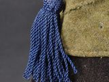 a close up of a hat with a tassel on it