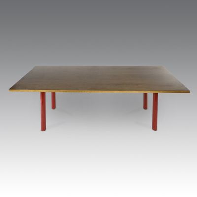 une table en bois aux pieds rouges sur fond gris
