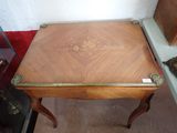 a small table with a wooden top and gold trimming