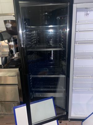 un réfrigérateur avec un ordinateur portable posé sur le plan de travail de la cuisine