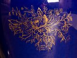 a blue vase with a gold design on it