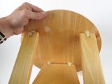 a person that is holding a wooden chair