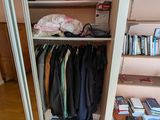 un placard contenant des vêtements et des livres rangés sur des étagères dans la pièce