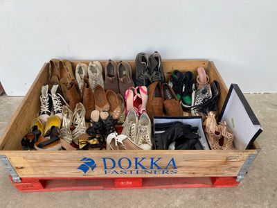 many pairs of shoes in a wooden box on the floor