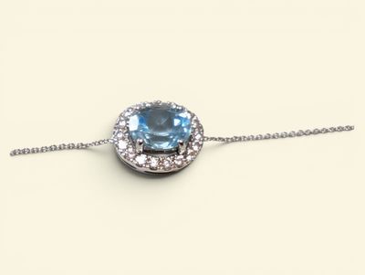 an image of a necklace with a blue topaz stone surrounded by white diamonds