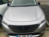 a silver car parked in a parking lot next to other cars