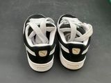 pair of black and white puma sneakers on a black surface