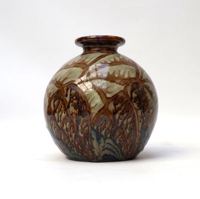 a brown and white vase sitting on a white surface