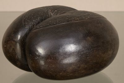 une sculpture représentant un beignet posée sur une table en verre