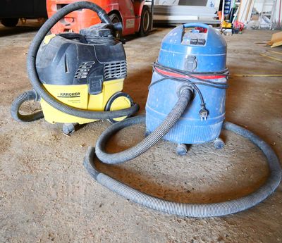 two vacuums that are on the ground in the garage