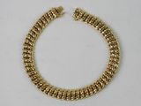 a gold bracelet on a white background