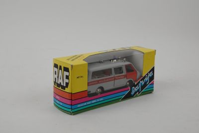 une camionnette miniature qui se trouve dans une boîte posée sur une surface blanche