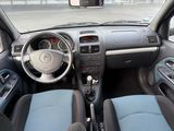 l'intérieur d'une petite voiture avec des sièges bleus et des commandes au volant