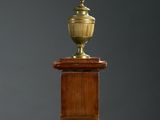 a gold vase sitting on top of a wooden table