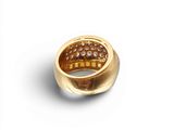a close up of a gold ring on a white surface