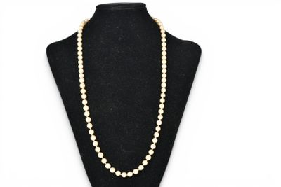 a white pearl necklace on a black mannequin