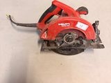 a red circular saw sitting on the floor in a room