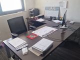 a desk with a computer, monitor, keyboard and other items on it