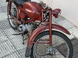 a red motorcycle parked on the sidewalk next to a building