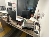 un bureau sur lequel sont posés deux écrans et un ordinateur portable